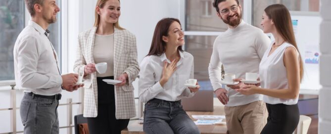 Team in ufficio durante uno small talk prima di una riunione, esempio di comunicazione informale sul lavoro