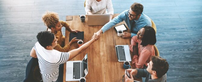 Team internazionale riunito intorno a un tavolo, esempio di collaborazione e integrazione in contesto lavorativo globale