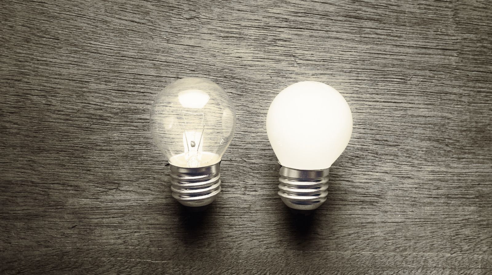 Due lampadine affiancate, una spenta e una accesa, rappresentano il passaggio da verbi formali a phrasal verbs nel Business English.