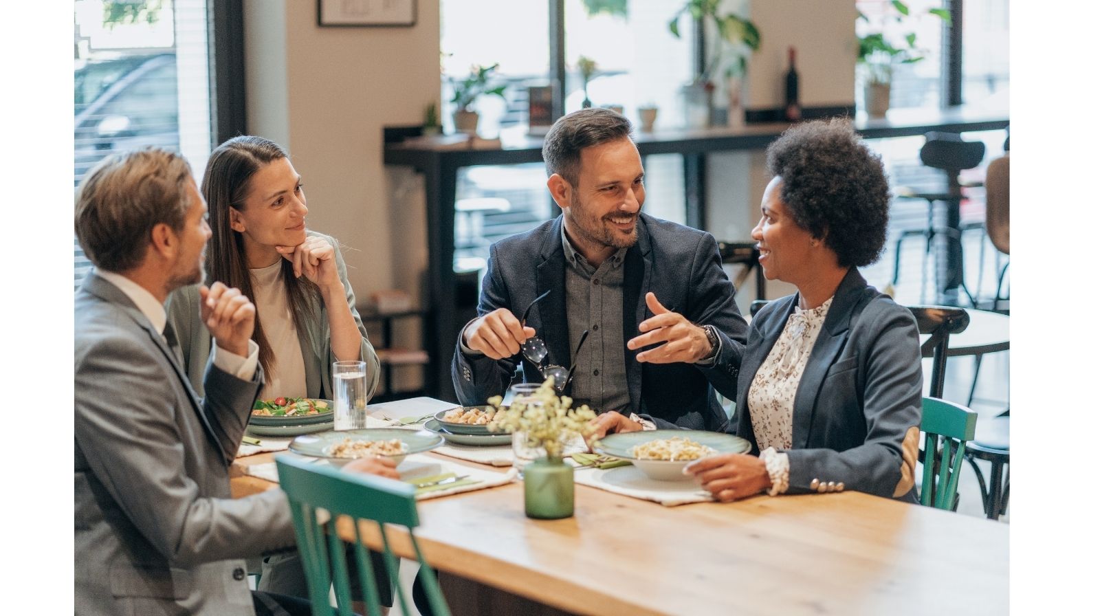 Professionisti durante una cena di lavoro mentre fanno small talk in inglese in un contesto internazionale.