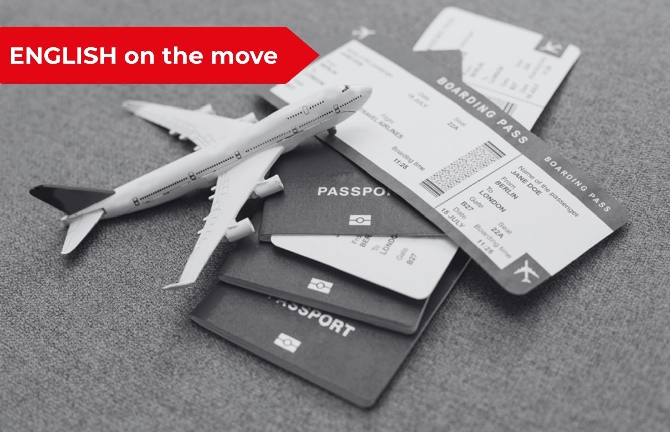 Passaporti e biglietti aerei con un aeroplano giocattolo e la grafica rossa English on the move per il blog di inglese per trasferte e viaggi di lavoro.