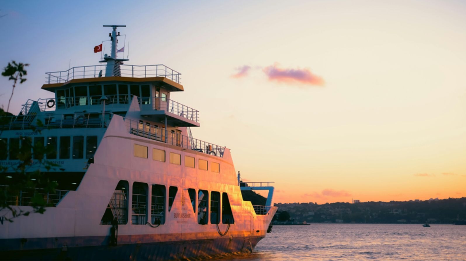 Grande traghetto passeggeri bianco vicino alla costa al tramonto per illustrare la situazione di un viaggio o traghetto perso in vacanza.
