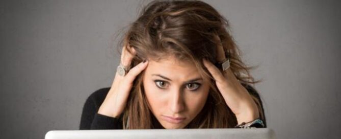 Donna stressata davanti al computer con banner Career Reload per articolo sul rientro al lavoro e gestione del carico professionale.